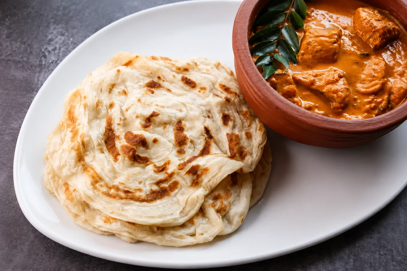 Kerala Chicken Curry with Porotta at Kerala Palace Restaurant Calgary — layered porotta with spiced chicken curry
